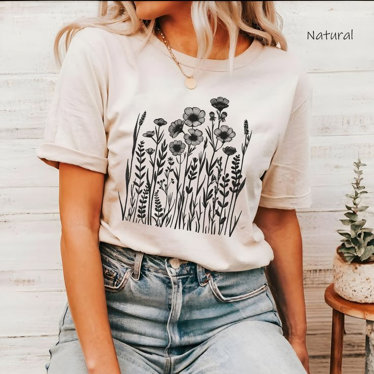 Embrace nature's charm with our Wild Flower TShirt! This soft, floral graphic tee blends boho chic style with a vintage look, perfect for casual summer days. Ideal for wildflower lovers and botanical enthusiasts, this top pairs effortlessly with any outfit. Enjoy the comfort and stylish flair of this unique piece! M A T E R I A L S → Simple Colors - 99% Airlume Combed and Ring-Spun Cotton, 1% Polyester → Heather and Solid Blend Colors - 52% Cotton, 48% Polyester → Black Heather - 90% Cotton, 10% Polyester. → Bella-Canvas Unisex Jersey Short Sleeve Crew-Neck Unisex T-Shirt → Soft and High-Quality Fabric → Sueded Jersey → Pre-shrunk → Taped Shoulder-to-Shoulder → Tear Away Label → Side Seamed → Retail Fit S I Z E → We Have a Size Chart in the Listing Photos. S H I P P I N G  &  P R O D U C T Botanical Printed Relaxed Fit T-shirt, Bohemian Spring T-shirt With Graphic Print, Spring Bohemian T-shirt With Screen Print, Bohemian Spring T-shirt With Floral Embroidery, Nature-inspired Crew Neck T-shirt For Summer, Spring Bohemian T-shirt With Graphic Print, Botanical Plants Print T-shirt With Relaxed Fit, Botanical Relax Fit T-shirt With Plant Print, Hippie Cotton T-shirt With Print