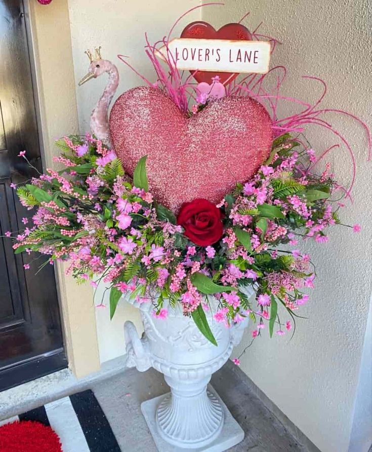 a vase filled with flowers next to a heart shaped sign that says love's lane