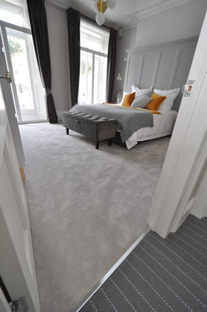 a bed room with a neatly made bed next to a doorway leading to another bedroom