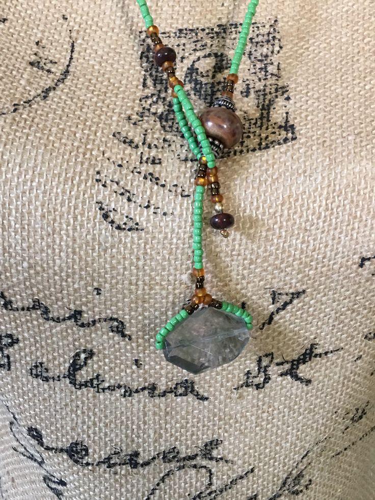 Striking Green and brown miyuki seed glass beads with brown jasper rondelle beads and green large stone focal piece lariat necklace? Very different and Quite eye-catching. length is adjustable depending on which loop you loop the green stone pendant through. Approximate length is 32-36 inches. You can make smaller by doubling it. Handmade by me.. Adjustable Green Beaded Lariat Necklace, Adjustable Green Bohemian Lariat Necklace, Adjustable Brown Beaded Necklaces Nature-inspired, Bohemian Green Beads, Gems, And Cabochons, Bohemian Green Natural Stones Beads And Cabochons, Brown Lariat Beaded Necklace Gift, Brown Lariat Beaded Necklace For Gift, Bohemian Brown Lariat Beaded Necklaces, Earthy Long Adjustable Beaded Necklace