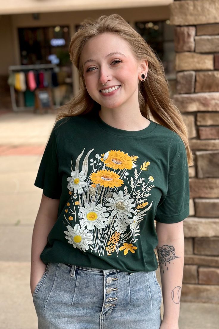 Daisy Floral Boho Graphic Tee Forest Green T-shirt color with ivory and yellow flowers This updated unisex essential fits like a well-loved favorite, featuring a crew neck, short sleeves and designed with superior combed and ring-spun cotton that provides amazing softness. Features: Sideseamed. Retail fit. Unisex sizing. Shoulder taping. Fabrication: 100% ring-spun cotton Fits TTS with a Unisex Fit. Printed on Bella Forest. Spring White Ring-spun Cotton Tops, White Ring-spun Cotton Tops For Spring, White Ring-spun Cotton T-shirt For Spring, Spring Short Sleeve T-shirt In Ring-spun Cotton, Spring Short Sleeve Ring-spun Cotton T-shirt, Spring Ring-spun Cotton Short Sleeve T-shirt, Spring Crew Neck T-shirt In Ring-spun Cotton, Spring Yellow T-shirt With Screen Print, Spring Relaxed Fit Ring-spun Cotton Tops