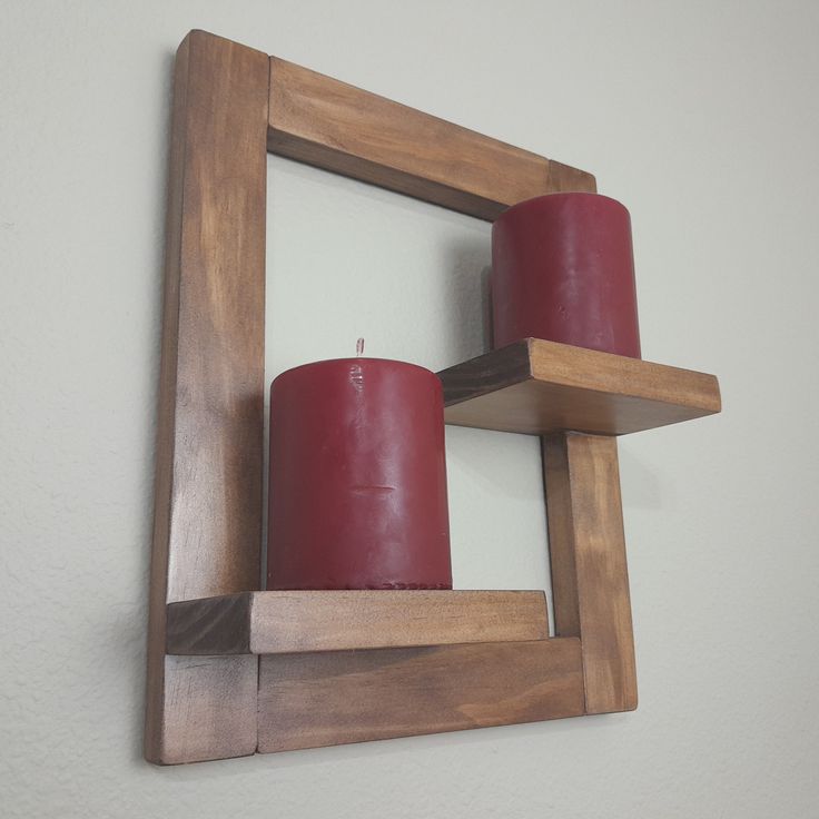 two red candles are placed in a wooden frame