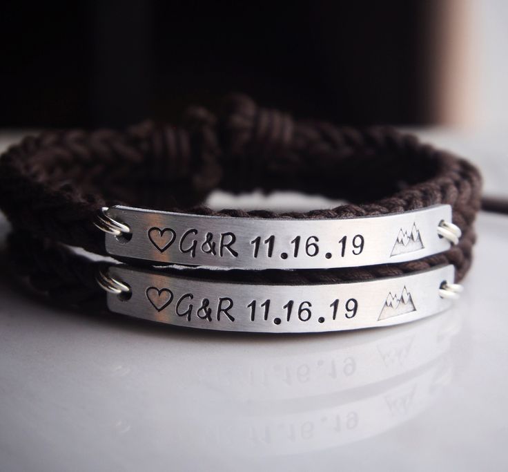 two personalized bracelets with names and hearts are shown on a white table top