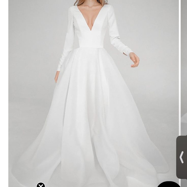 the back of a white wedding dress with long sleeves and a deep v - neckline