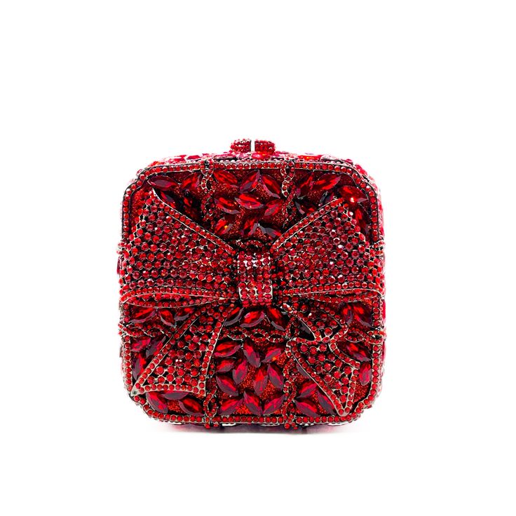 The Red Gift Box is a charming and dazzling box with a bow covered in radiating red crystals. A gorgeous clutch bag completed with black color hardware and removable black snap hook chain, perfect for wearing on hand. It is a gorgeous showstopper. Beautifully designed, this clutch can hold securely your keys, cards, and other small necessities. Details: Measurement:  5.5in length x 5.5in high x 2in width; depth: 5in Color: red Lining: sliver vegan leather Closure: magnetic closure Chain length: 19in Glamorous Red Evening Clutch, Luxury Red Clutch For Evening, Glamorous Red Clutch For Events, Red Rhinestone Bag Perfect For Gifts, Red Rhinestone Bag For Gift, Red Rhinestone Bag As Gift, Luxury Red Rectangular Clutch, Elegant Valentine's Day Rectangular Evening Bag, Elegant Clutch For Valentine's Day Gift