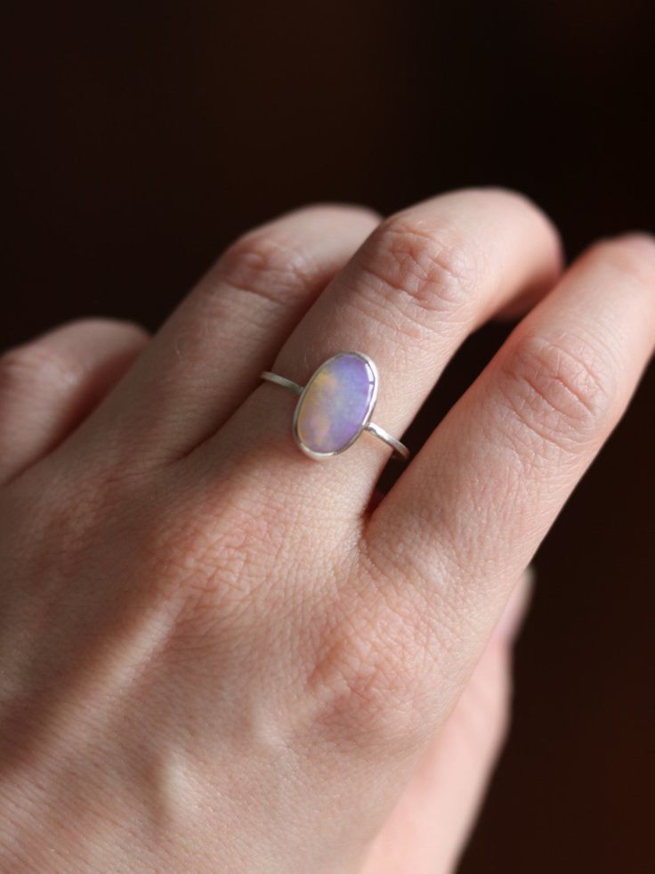 This dainty and extremely delicate ring features a beautiful Australian Lightning Ridge opal, set in a fine silver bezel with open back. The band is made with a sterling silver square wire. Size 8.25Handmade It's a perfect everyday ring - simple, yet full of character. Can be stacked and combined with other rings or worn by itself, for a more minimalist look. Delicate purples make each opal absolutely unique, with its own stunning colours and inclusions. The look of the gemstone changes in diffe Australian Opal Ring, Lightning Ridge Opal, Everyday Ring, Ring Simple, Everyday Rings, Lightning Ridge, Delicate Rings, Opal Ring, Australian Opal