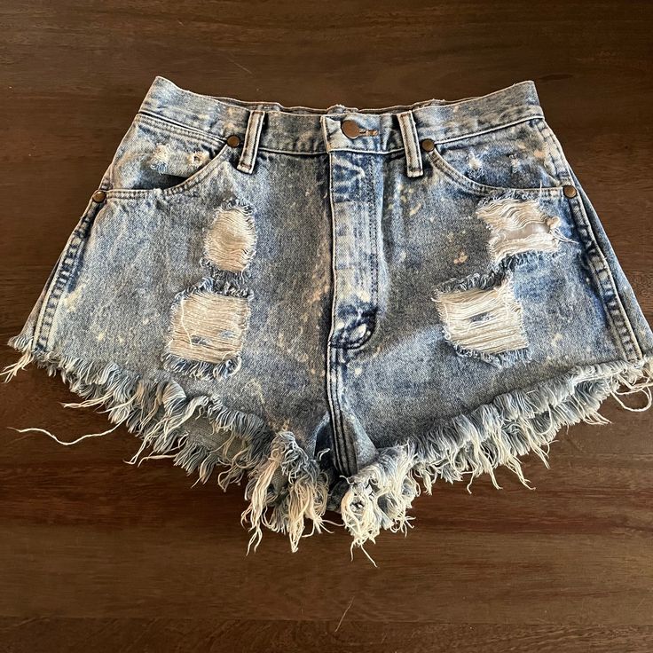 "Trashed Vintage 1980s Wrangler Cutoff Jean Shorts High Waist  Regular Fit  Button Fly  Acid Wash Denim  Size 11  Distressed Denim  Measurements (Flat Across)  Waist: 13\"  Rise: 12\"  Hips: 20\"  Legs Opening: 11\" Length: 10\" Made in USA" Medium Wash Bottoms For Spring Rodeo, Cotton Bottoms For Summer Rodeo, Western Style Summer Bottoms For Rodeo, Cotton Bottoms For Rodeo In Summer, Western Style Summer Rodeo Bottoms, Spring Vintage Distressed Bottoms, Western Denim Bottoms For Summer, Western Style Denim Bottoms For Summer, Western Style Denim Bottoms For Spring