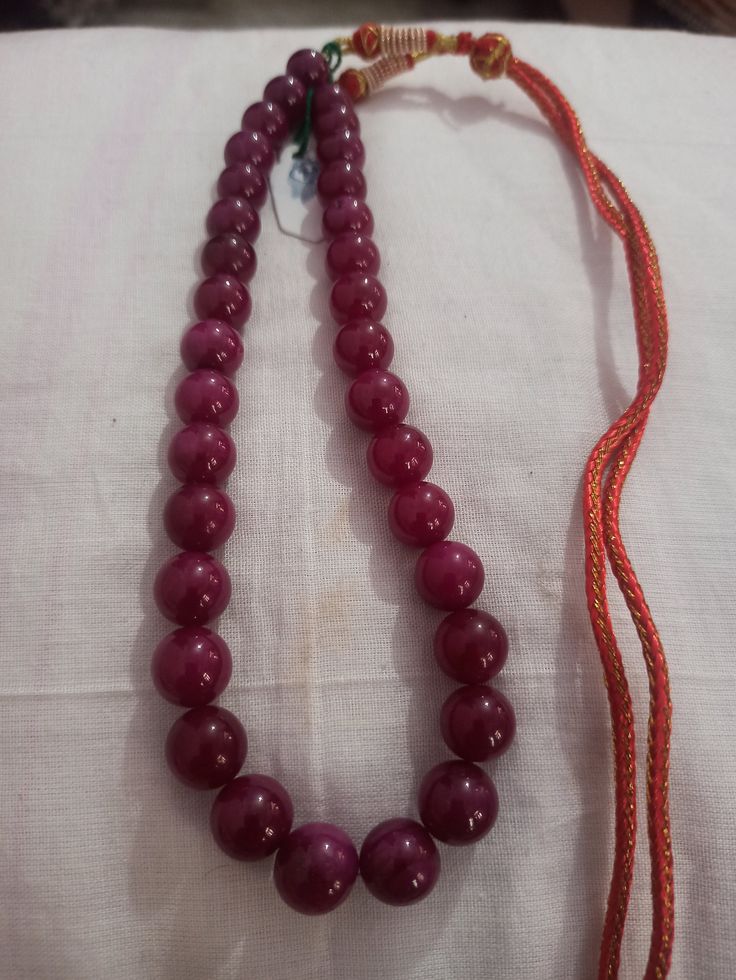 Ruby Necklace Natural Ruby Corundum Smooth Round Beads 513 Carat AAA Ruby Necklace With Adjustable Code Necklace 1.Ruby Corundum 2. Ruby Round Beads 3. 14 inches length, 1 Line String 4. 513 -carat weight 5. 10x10 - 12x12 mm stone size 6, The necklace is with tassel because you can easily adjust your necklace length. 7. If you want any changes in the necklace example if you want with clasp we can do it. Polish :- Handmade Purity :- AAA These natural Ruby gemstones can be used to make different j Traditional Ruby Necklaces With Round Beads, Traditional Ruby Necklace With Round Beads, Traditional Round Beaded Necklaces For Formal Occasions, Traditional Round Beaded Necklace For Formal Occasions, Traditional Beaded Necklace For Formal Occasions, Traditional Red Round Beads, Gems, And Cabochons, Temple Jewelry Necklaces With Polished Beads, Traditional Red Beads, Gems, And Cabochons, Gift Polished Round Beads