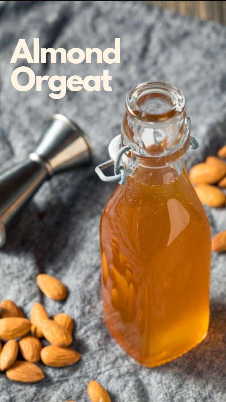 almond oil in a glass bottle next to almonds on a gray towel with the words almond or great written above it