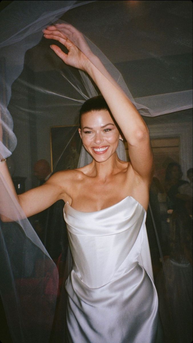 a woman in a white dress posing for the camera