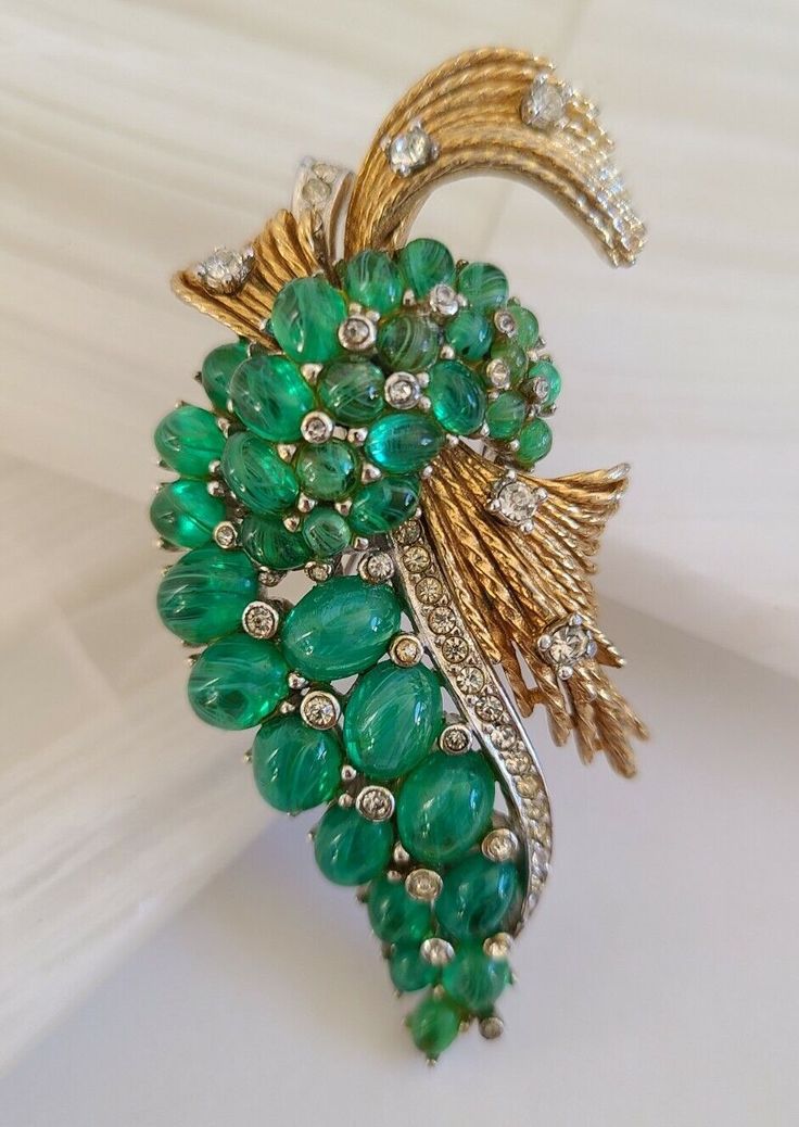 Up for sale is this this Stunning Ciner Silver & Gold Tone Green Cabochon & White Rhinestones Brooch, Signed Piece. This beautiful piece is in vintage pre-owned condition with no missing elements. It is inches 2 3/4 inches H x 1 3/8  inches W (widest point). Please See all pictures (ZOOM IN) as this is the main part of the description. Feel free to ask all questions before purchase. All sales are final. NO Returns. See my other listings to look at other beautiful vintage jewels. Thanks for watching. Shipped with USPS first class mail. Elegant Green Rhinestone Brooches, Antique Green Clip-on Jewelry, Antique Green Gemstone Brooches, Vintage Green Rhinestone Brooch, Vintage Gold Multi-stone Brooches, White Rhinestone, Rhinestone Brooches, Thanks For Watching, Vintage Jewels