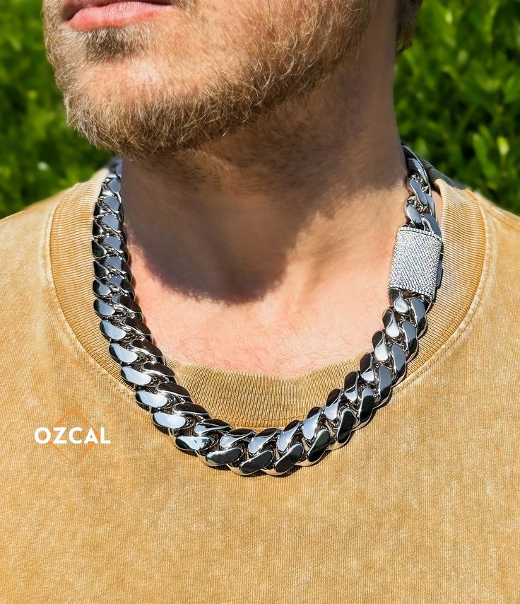 Welcome to OZCAL Jewelry! Introducing our luxurious 20mm heavy 18K gold plated 925 sterling silver Cuban link chains and bracelets, perfect for those who appreciate high-quality, stylish, and robust jewelry. These pieces are meticulously crafted with a VVS1 Moissanite box clasp, ensuring they pass the diamond tester with ease. Whether you prefer the bold look of a Cuban link chain or the elegance of a bracelet, these pieces are sure to make a statement. Features: - Width: 20mm - Lengths for Brac Iced Out Cubic Zirconia Jewelry For Streetwear, Streetwear Iced Out Jewelry With Cubic Zirconia, Streetwear Iced Out Cubic Zirconia Jewelry, Luxury Diamond Jewelry For Streetwear, Luxury Bling Jewelry For Streetwear, Silver Cuban Link Necklace Iced Out With Cubic Zirconia, Silver Cuban Link Necklace With Iced Out Cubic Zirconia, Luxury Silver Jewelry For Streetwear, Iced Out Chain Link Jewelry For Streetwear