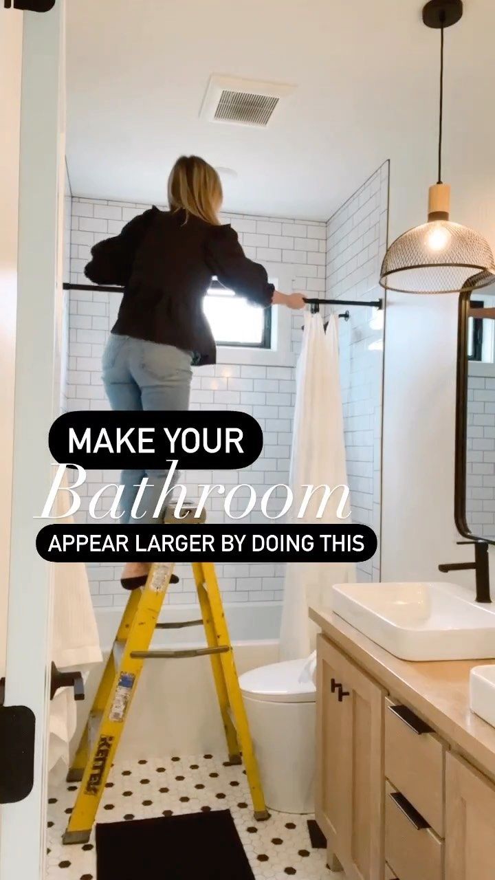 a woman standing on a ladder in a bathroom with the words make your bathroom appear larger by doing this