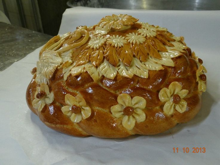 a bread with flowers on it sitting on a table next to a potted plant