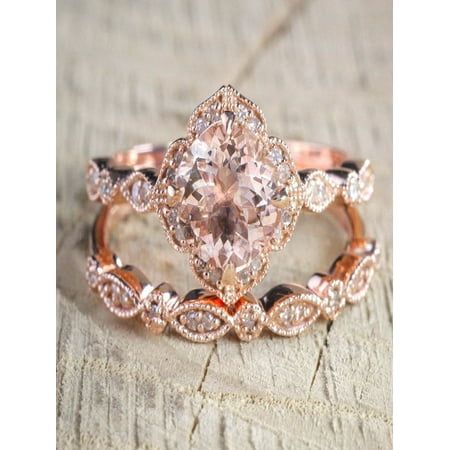 an engagement ring with a pink diamond in the center on top of a piece of wood