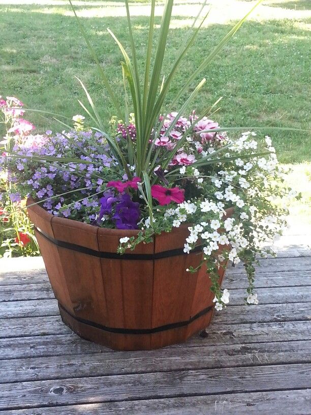 a wooden barrel filled with lots of flowers