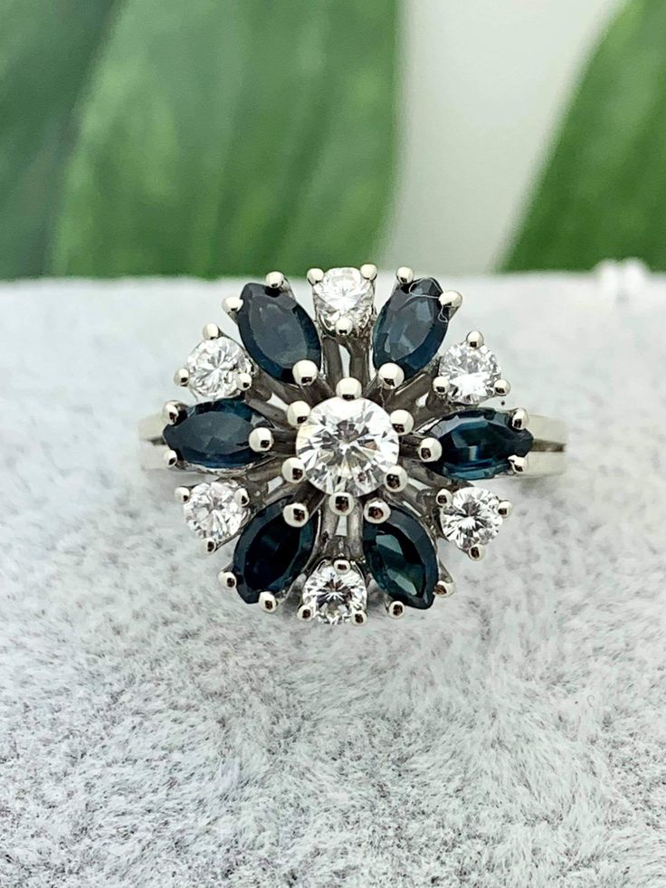 Very CHIC 18K White Gold Diamond and Sapphire Cocktail Ring--This is a right and ring if we've ever seen one! Diamonds are round and sapphires are marquise cut. Center diamond 4mm = .23 Ct 6 surrounding diamonds 2.5mm each = .36 TCW All diamonds are F-G in color, SI1 in clarity - very nice! Size 7.25 6 Marquise Sapphires: 5mm x 3mm = 1.2 CTW Weight 5.6g We can resize rings for a fee. Please ask any questions! Multi-stone Round Sapphire Ring In Platinum, Platinum Multi-stone Cluster Diamond Ring, Platinum Cluster Multi-stone Diamond Ring, Diamond White Multi-stone Ring For Formal Occasions, White Gold Marquise Multi-stone Diamond Ring, Diamond White Multi-stone Marquise Rings, Diamond White Marquise Multi-stone Ring, Multi-stone Platinum Sapphire Ring For Anniversaries, Round Multi-stone Platinum Diamond Ring