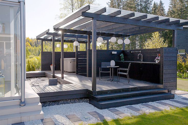 an outdoor kitchen and dining area in a backyard