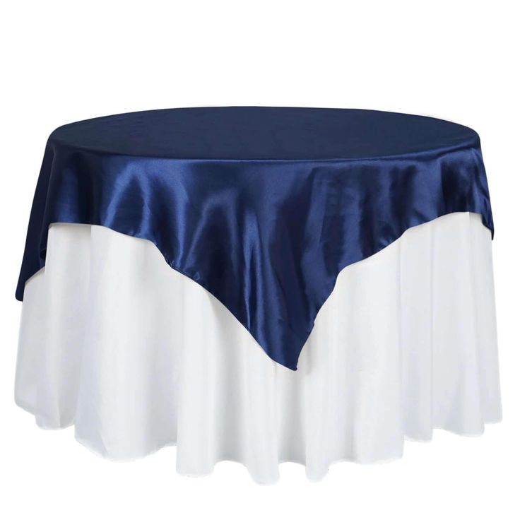 a blue and white table cloth on top of a round table with an overlay