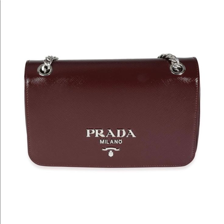 This Stunning Prada Crossbody / Shoulder Bag Is Made Of Shinny Saffiano Vernic Leather With Polished Silver-Tone Hardware. Details Include A Long Chain And Leather Shoulder Strap, Flop Closure And Logo Jacquard Lined Interior With One Zipper And One Wall Pocket. Measurements: 9" Long, 5.5" High, 2.5" Deep Material: Saffiano Leather Color: Granato / Burgundy Brand New Dust Bag Only Luxury Crossbody Bag With Logo Plaque, Luxury Business Bags With Logo Plaque, Elegant Rectangular Shoulder Bag With Logo Plaque, Luxury Bags With Logo Plaque, Elegant Rectangular Bag With Logo Plaque, Luxury Formal Bag With Logo Plaque, Luxury Formal Bags With Logo Plaque, Designer Saffiano Leather Shoulder Bag, Elegant Crossbody Bag With Logo Plaque