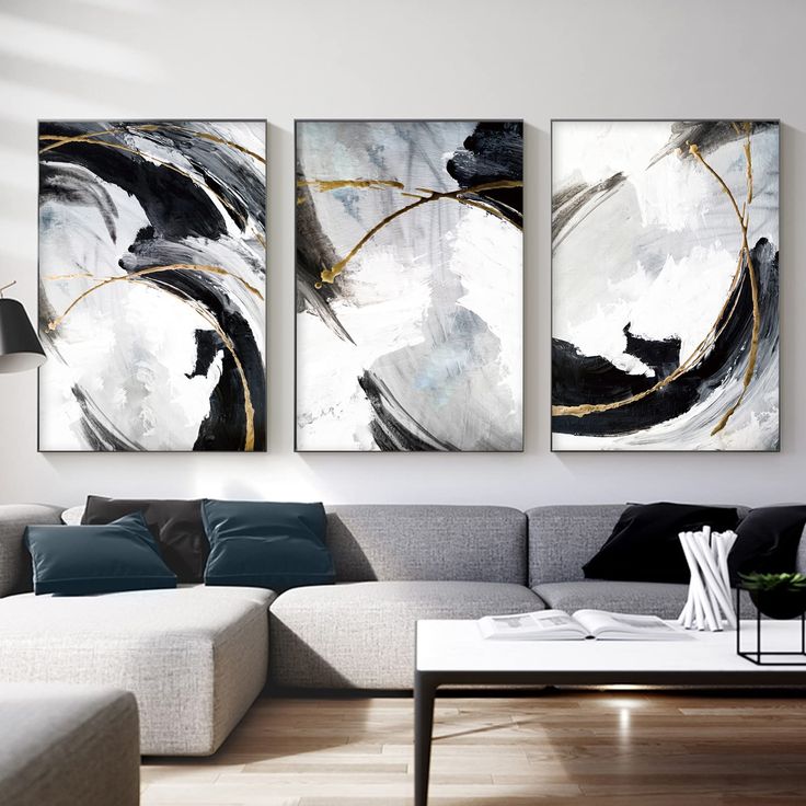 three paintings on the wall in a living room