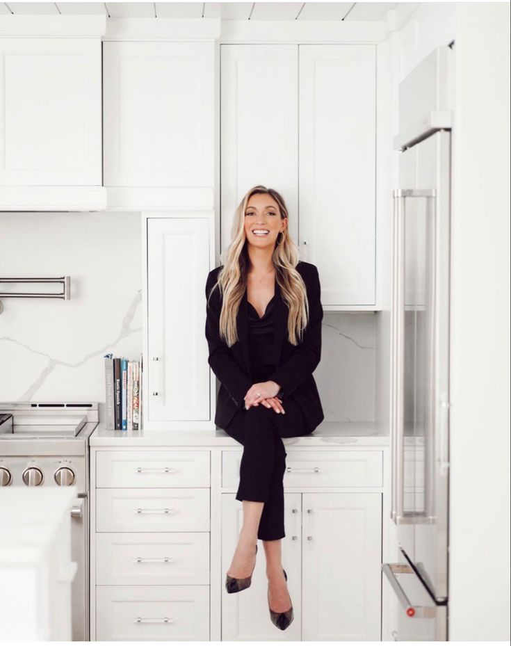 a woman sitting on top of a kitchen counter