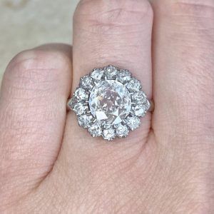 a person's hand with a diamond ring on top of their finger and an engagement ring in the middle