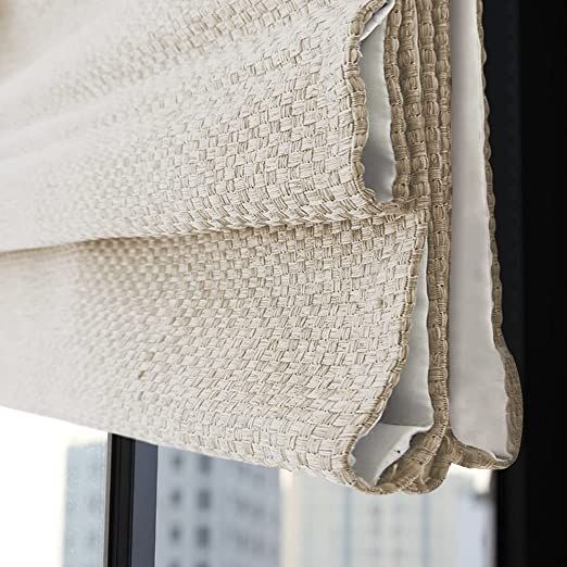 an open window with a curtain pulled up to the side and some white fabric on it