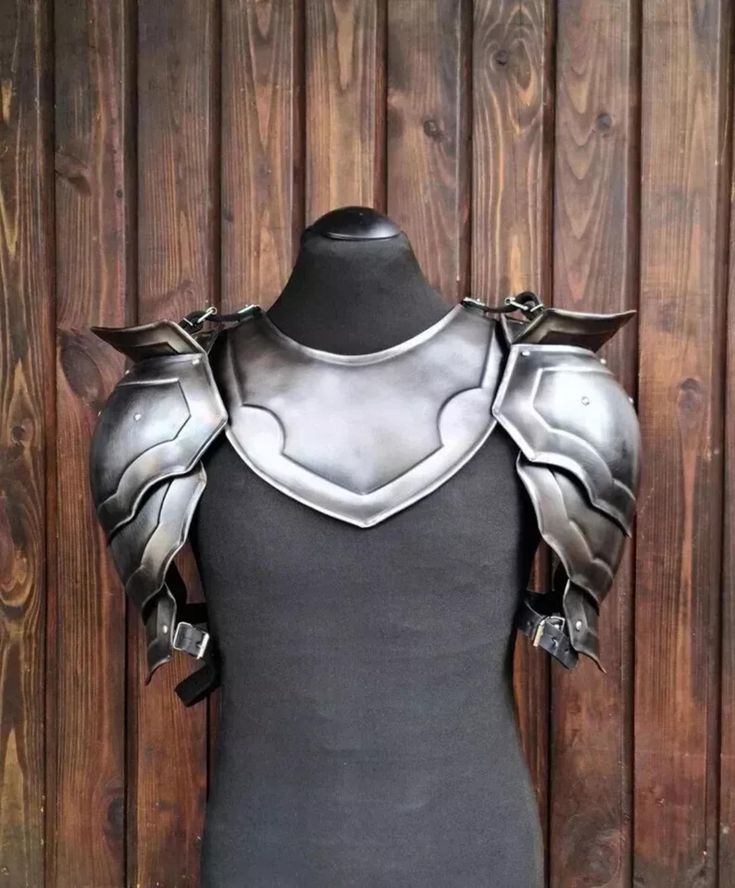 a mannequin with armor on it's chest and shoulder pieces in front of a wooden wall