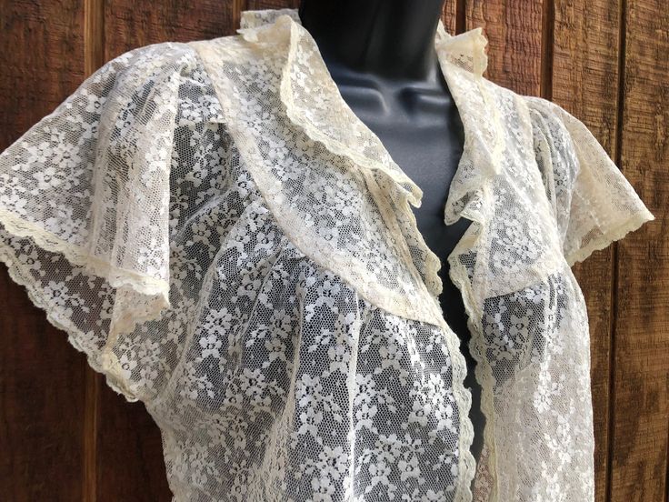 This elegant lace bolero is a unique layering piece, perfect for the bedroom, or as a dramatic addition to any outfit. No tags - estimated size small to medium . In good vintage condition.  19" armpit to armpit 18" length Fitted Bohemian Lace Top For Daywear, Vintage Lace Top With Lace Trim For Spring, Spring Vintage Lace Top With Lace Trim, Vintage Lace Patchwork Top For Spring, Vintage Lace Top For Spring, Vintage Lace Blouse For Spring, Vintage Fitted Lace Top For Spring, Sheer Lace Blouse For Daywear, Vintage Lace Top With Ruffles