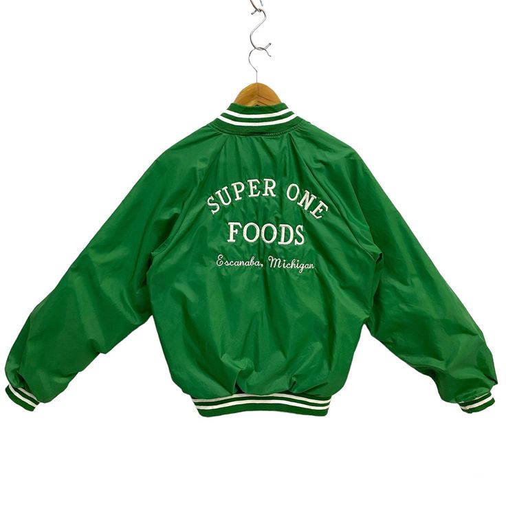 "Vintage Super One Foods Escanaba Michigan Staff Jacket Hartwell USA Varsity Jacket Light Nylon Bomber Raglan Snap Button Embroidery Green Medium * Used. In good condition (7/10) minor signs of wear with some small light marks/spots, a few thread pulled on both sleeves (view photos) * Tagged size Medium (38-40). Flat laid measurements in inches (appox) - Chest (underarm to underarm) : 22\" - Length (side of neck seam to bottom hem) : 25\" BUY 3 ITEMS GET FREE SHIPPING WORLDWIDE ATTENTION : PLEAS Retro Winter Outerwear With Embroidered Graphics, Retro Long Sleeve Outerwear With Letter Embroidery, Retro Outerwear With Embroidered Graphics For Fall, Retro Fall Outerwear With Embroidered Graphics, Sporty Green Outerwear With Embroidered Logo, Green Embroidered Logo Outerwear For Streetwear, Green Embroidered Streetwear Outerwear, Green Embroidered Outerwear For Streetwear, Embroidered Green Outerwear For Streetwear