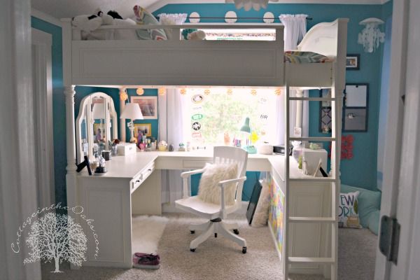 a bedroom with a loft bed, desk and chair in the corner on carpeted flooring