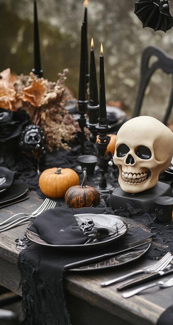 a table topped with black plates and halloween decorations