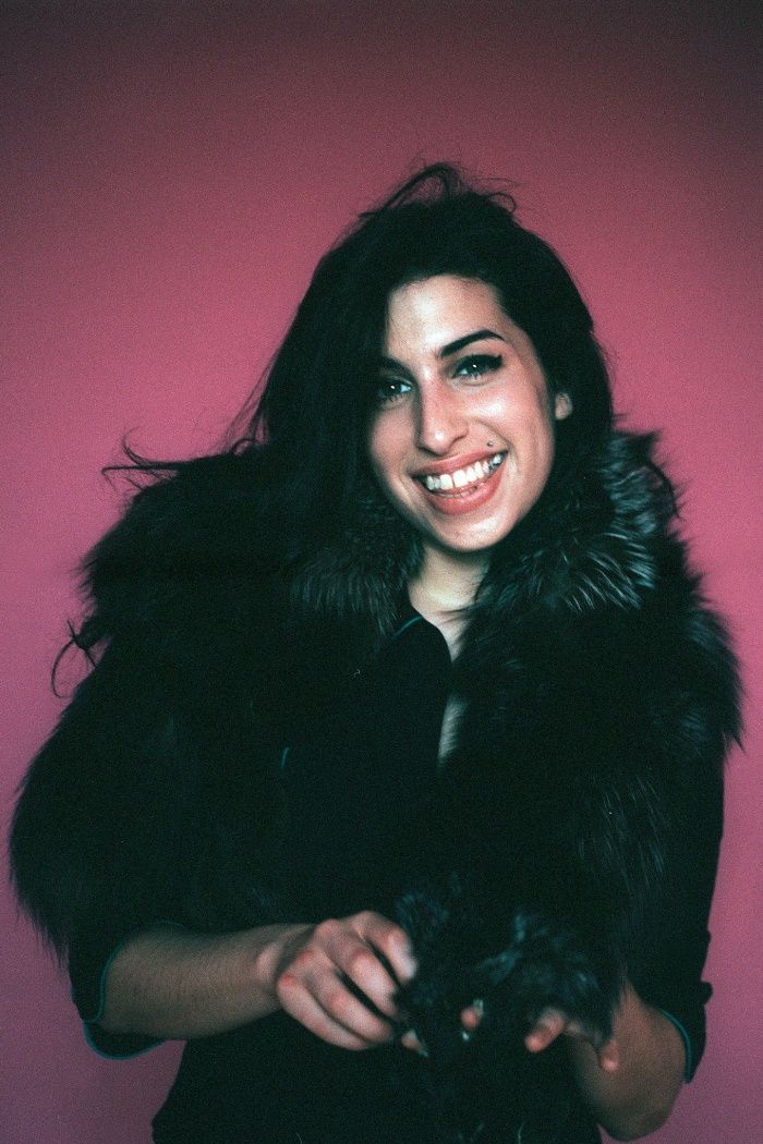 a woman wearing a fur coat and smiling