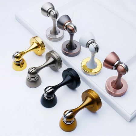 several different colored handles and knobs on a white surface, one is gold, the other is silver