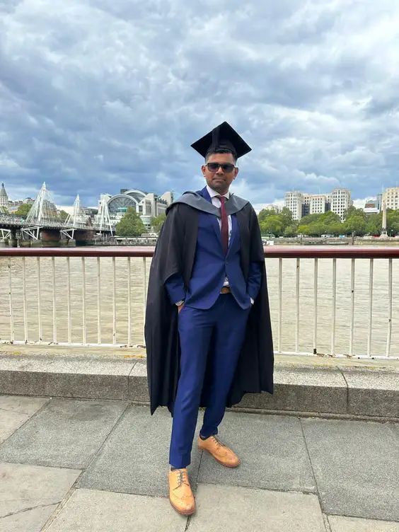 a man in a blue suit and graduation cap