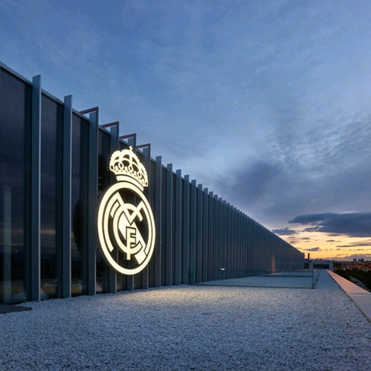 an illuminated sign on the side of a building that says'real madrid'at night