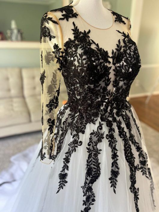 a black and white dress on a mannequin in front of a bed room