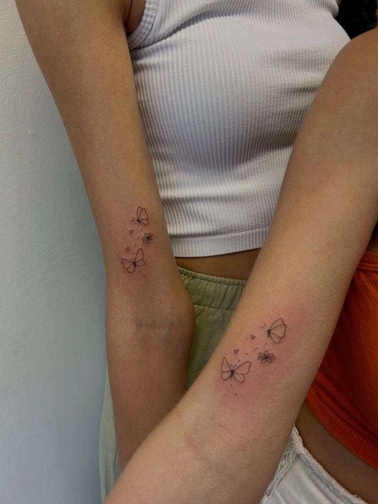 two women with matching tattoos on their arms