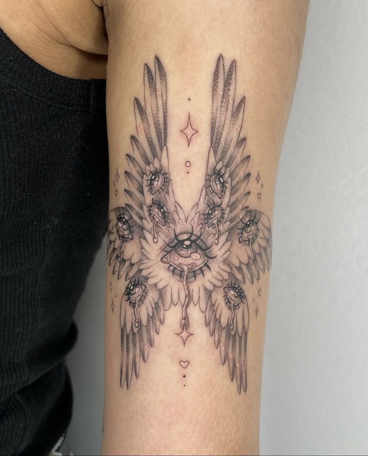 a woman's arm with an eagle tattoo on the back of her body and wings