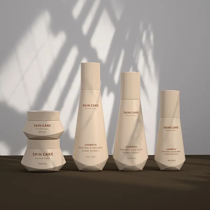 five bottles of skin care are lined up against a white wall with shadows on it