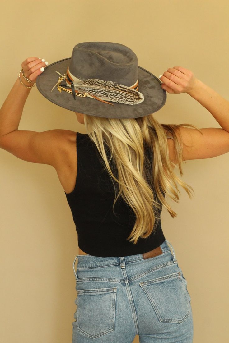 Our love of hats just got became a full-on obsession: meet the Navajo Feather Banded Hat in Grey. The most chic, high-end hat we could've ever dreamed up. A hat this good needs to be worn as much as possible and with every single outfit! Hand made by artisans, incredible quality, pure suede, genuine leather trim around the crown, authentic feathers, chain, too many details to list! The best part? It's super structured with an elastic band on the inside that will fit EVERYONE. Btw never taking th Flat Brim Feathered Ranch Hat, Fedora With Feather Trim For Rodeo, Western Wide Brim Hats With Feathers, Wide Brim Fedora With Feathers For Rodeo, Rodeo Fedora Hat With Feather Trim, Wide Brim Hat With Feather Trim For Fall, Rodeo Fedora With Feather Trim, Fall Wide Brim Hat With Feather Trim, Western Fedora Hat With Feather Trim