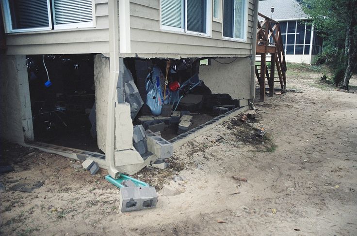 a house that is under construction with tools in the front yard and an open garage door