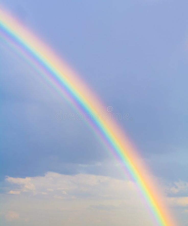 a rainbow in the sky with clouds above it