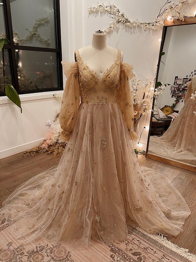 a dress is on display in front of a mirror and some lights are hanging from the ceiling