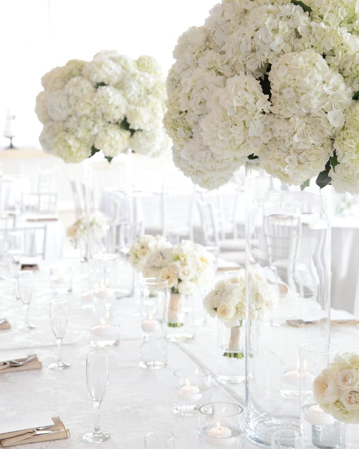 the tables are set with white flowers and candles