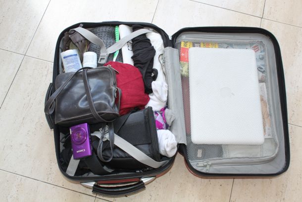 an open suitcase filled with personal items on the floor