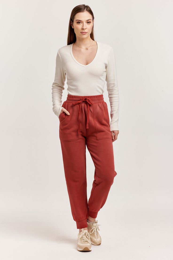 image of a female model wearing a DAHLIA HIGH RISE ANKLE JOGGER PANTS INTENSE RUST DEAR JOHN DENIM Everyday Sporty Cargo Pants With Elastic Waistband, Athleisure Cargo Pants For Everyday, Sporty Everyday Cargo Pants With Elastic Waistband, Cotton Cargo Pocket Joggers For Loungewear, Sporty Tapered Leg Cargo Pants For Fall, Tapered Leg Cargo Pants With Pockets For Loungewear, Tapered Leg Cargo Pants For Loungewear, Athleisure Sweatpants With Pockets, Athleisure Joggers With Side Pockets For Elevated Casual Wear