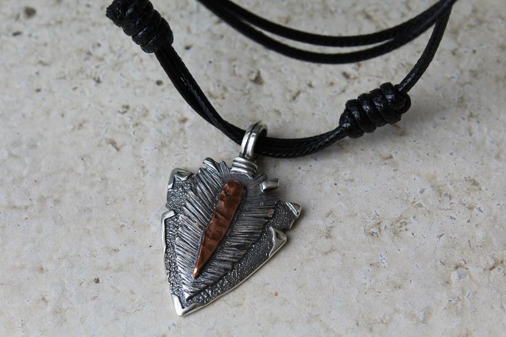 Arrowhead.Men's pendant.Silver arrowhead.Mixed metal.Arrowhead necklace.Art jewelry.Rustic. Artisan arrowhead with mixed metal- sterling silver 925 and copper element. The design of the necklace is inspired by the freedom and power of ancient man. It was completely hand sculpted and handmade in our Atelier - Alemard. Guarantee for the perfect quality of our jewelry. Arrowhead pendant has a size of 42 mm. (1.65 inches) in length, 25 mm. (1 inches) width. The edges of the wax cord slip to each oth Copper Element, Rustic Arrowhead Necklace For Gift, Handmade Sterling Silver Arrowhead Necklace, Bohemian Silver Arrowhead Necklace, Arrowhead Pendant Necklace, Arrowhead Pendant, Jewelry Rustic, Arrowhead Necklace, Necklace Art