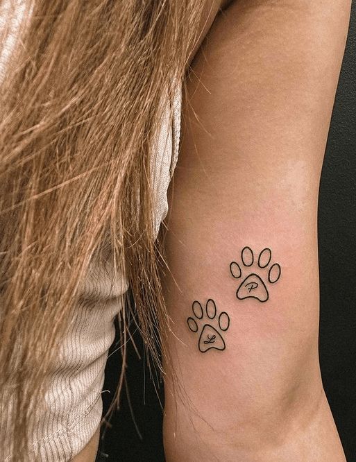 a woman with a dog paw tattoo on her arm